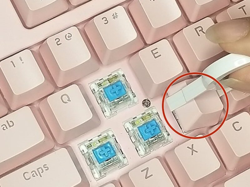 Close-up of the keyboard with keycap puller positioned under the keycap